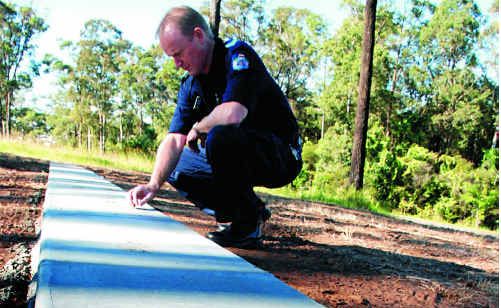 Damage by vandals in the new baby section of the Gympie Cemetery has left cemetery supervisor Lee Selby lost for words. Sergeant John Cain (pictured) investigates. Damage by vandals in the new baby section of the Gympie Cemetery has left cemetery supervisor Lee Selby lost for words. Sergeant John Cain (pictured) investigates.